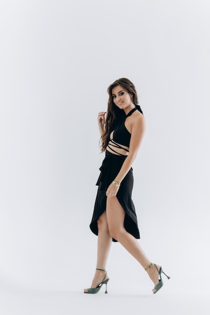 Sexy woman in studio. Woman in black dress on white