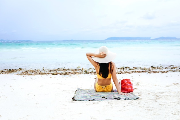 Photo sexy woman with bikini sitting on the beach.