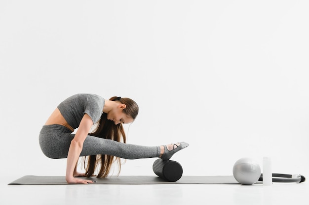 Sexy young female doing exercise on isolated white background