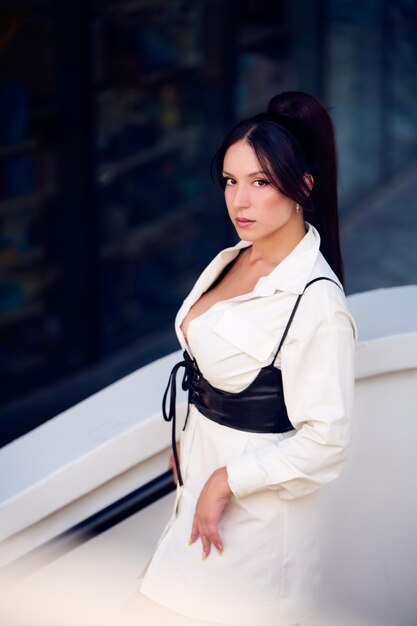 Sexy young girl dressed in a white dress and sunglasses on a sunny afternoon