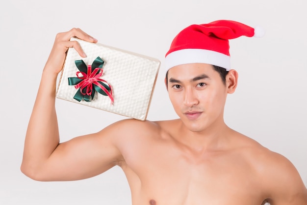 Sexy young man with  red santa claus's hat outfit holding his gift box.