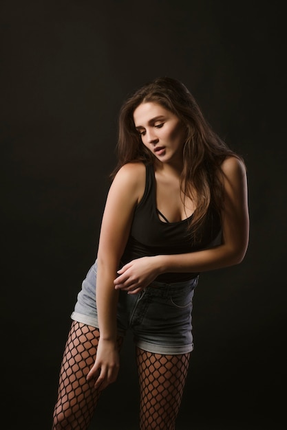 Sexy young model posing for model tests on a black background at studio