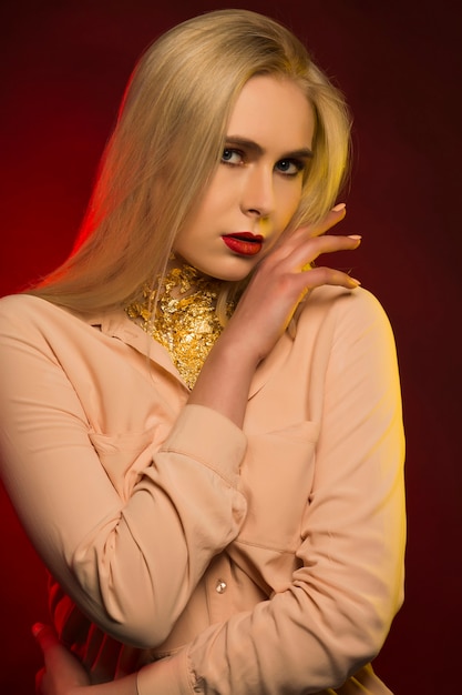 Sexy young model with bright makeup. Red and yellow studio light