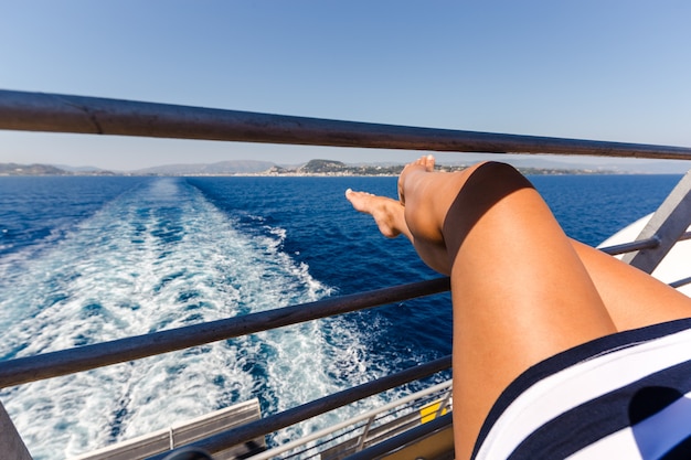 Sexy young woman legs relaxing on cruise ship travel holiday