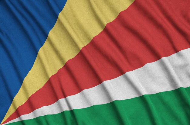 Seychelles flag  is depicted on a sports cloth fabric with many folds. 