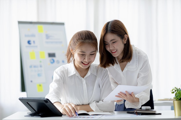 Sfeer in het kantoor van een startend bedrijf twee vrouwelijke werknemers bespreken brainstormideeën om te werken aan samenvattingen en marketingplannen om de verkoop te vergroten en rapporten voor managers op te stellen