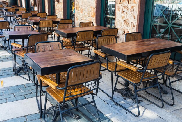 Sfeervolle zomerfotografie houten caféstoelen en tafels outdoor straatcafé