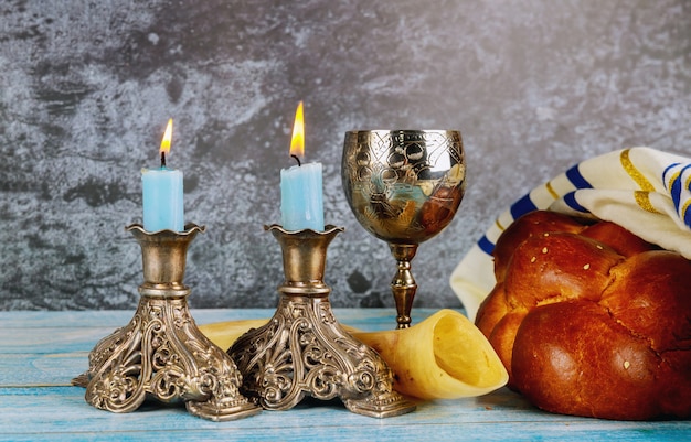 Photo shabbat challah bread, shabbat wine and candles on the table