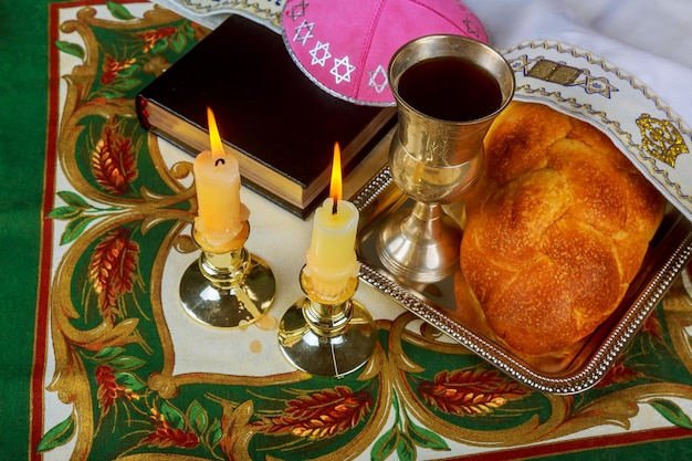 Shabbat-kaarsen in glazen kandelaars met wazige bedekte challah-achtergrond