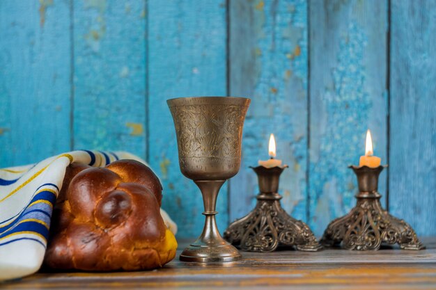 Shabbat-kaarsen in glazen kandelaars Wazig challahbrood