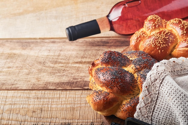 Photo shabbat shalom bread challah with sesame seeds and poppy seeds on wooden background traditional jewish bread for shabbat and holidays rustic concept copy space selective focus