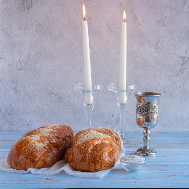 Shabbat shalom challah pane shabbat vino e candele sul tavolo di legno