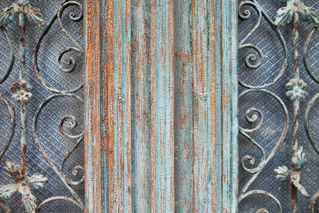 골동품 화려한 금속 격자와 초라한 어두운 페인트 나무 액자 문 무늬 격자 텍스처입니다. 오래 된 건물의 빈티지 문의 건축 세부 사항