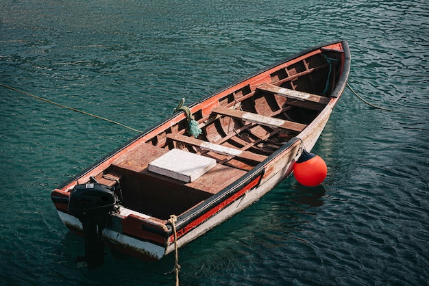 Shabby fishing boat floating in sea water