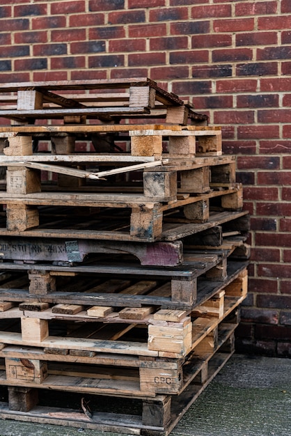 Shabby wooden pallets near brick wall