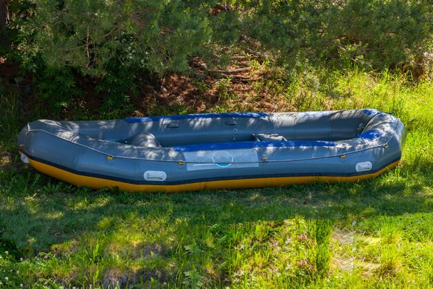 Photo in the shade under the trees large inflatable rafting boat near the river in the altai mountains extreme sports and recreation