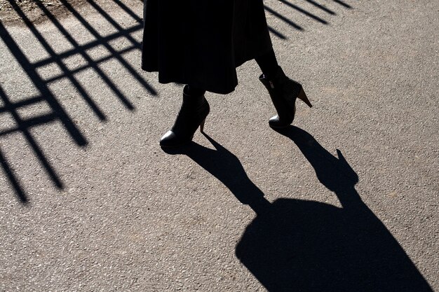 The shadow on the asphalt of female legs in high heels