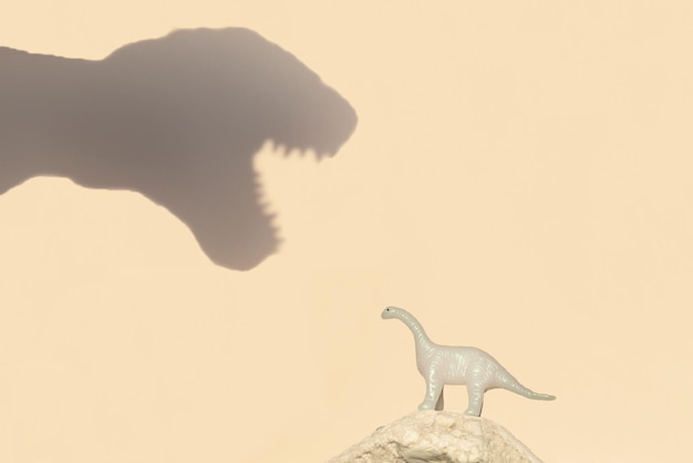 Foto l'ombra di un grande dinosauro e il concetto di educazione di un piccolo dinosauro