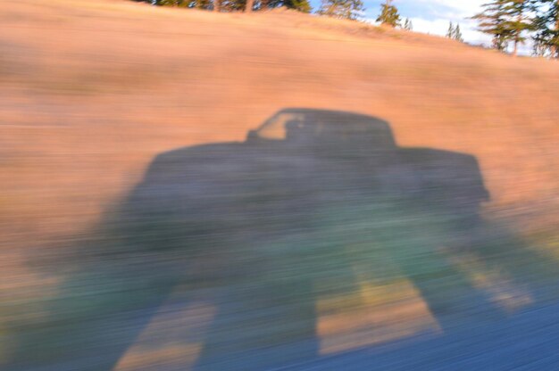 Foto ombra di un'auto su un campo sfocato