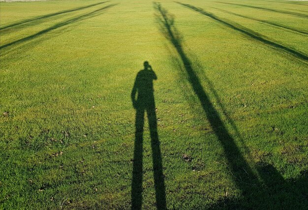 Photo shadow of man on grassy field