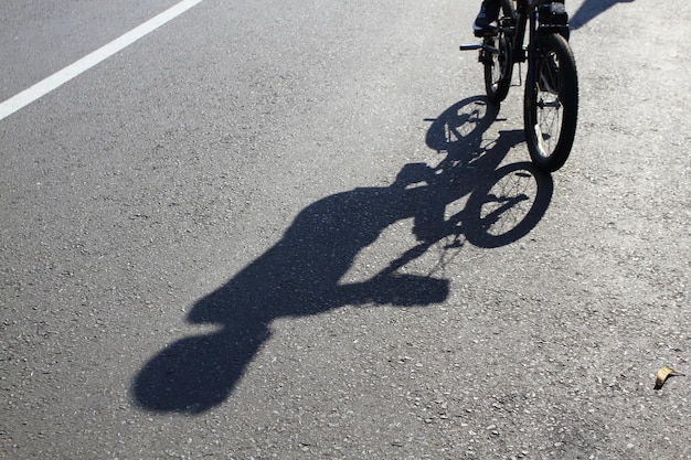 路上で自転車に乗る男の影