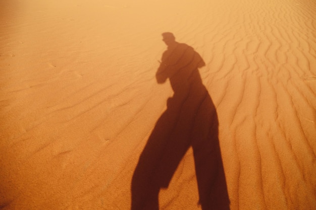 Photo shadow of man on sand dune