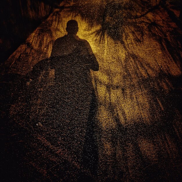 Photo shadow of man on street at night