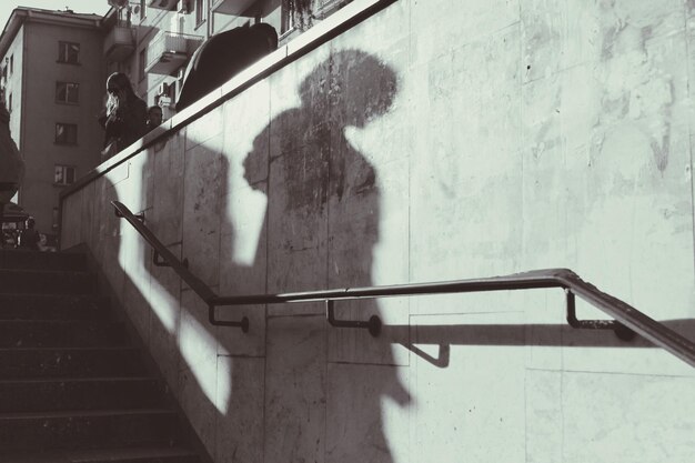 Photo shadow of man walking on staircase