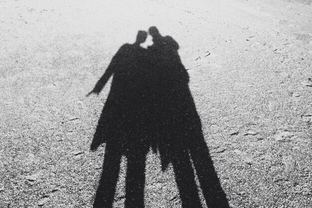 Photo shadow of man and woman on field