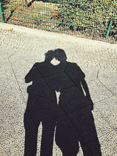 Photo shadow of man and woman on street