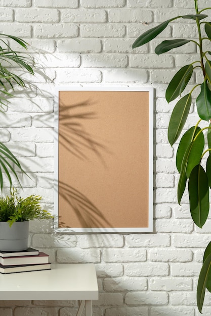Фото Тень пальмовых листьев, брошенная на обрамленную картину на белой кирпичной стене