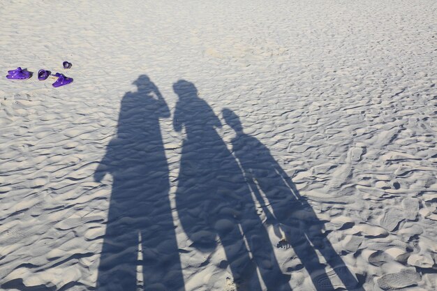 Photo shadow of people on sand at beach