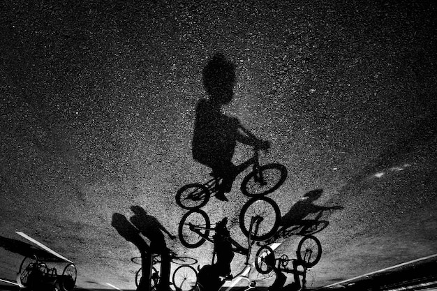 Photo shadow of people with bicycle on street