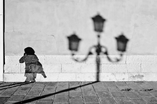 Shadow of person and street light on wall