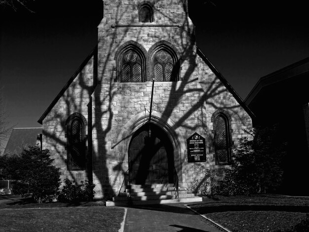 Photo shadow on trees on church wall during sunny day