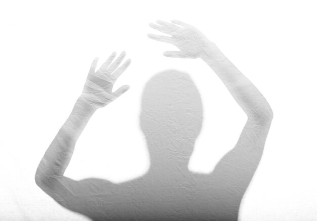 Photo shadow of woman with arms raised on white wall