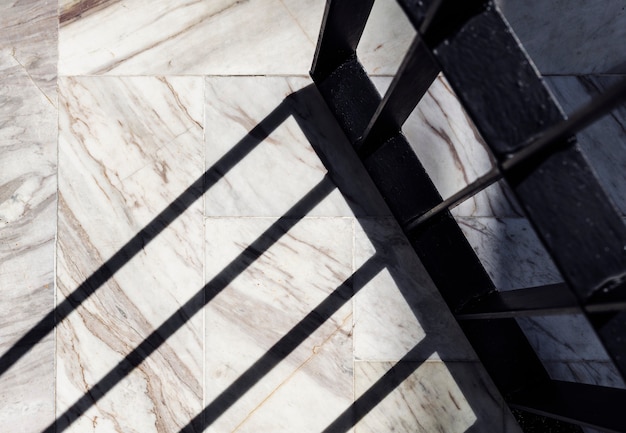 Photo shadow of a wrought iron door on a white marble floor