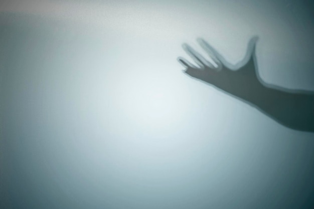 Shadow of a zombie's hand on a colored background Scary Halloween concept