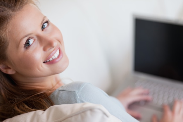 Shadowing woman with laptop on the sofa