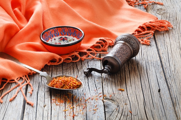 Shafran in een lepel op houten tafel met zijden doek