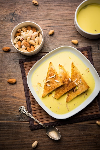 Shahi tukra of tukda of Double ka meetha is een Indiase broodpudding van gebakken sneetjes brood gedrenkt in hondsdolle of zoete saffraanmelk gegarneerd met droog fruit, selectieve focus