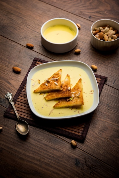 Shahi tukra or tukda or Double ka meetha is a bread pudding Indian sweet of fried bread slices soaked in rabid or sweet saffron milk garnished with dry fruits, selective focus