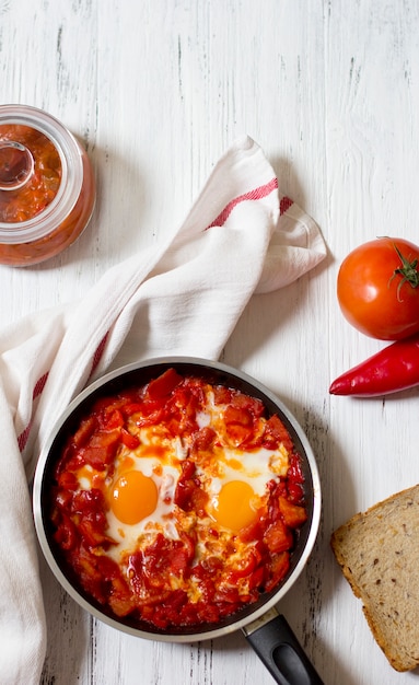 Shakshoukaまたはshakshuka、トマトとピーマンのソースの卵、トップビュー