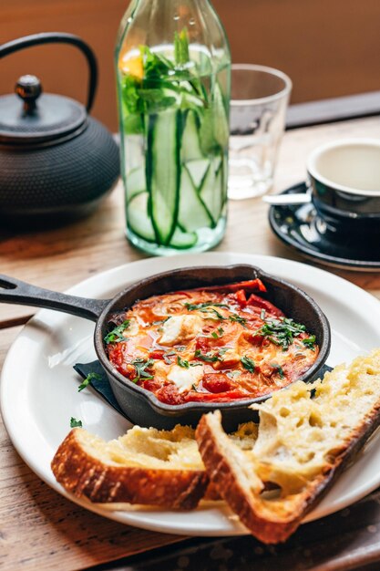 Shakshuka in ijzeren pan geserveerd met brood