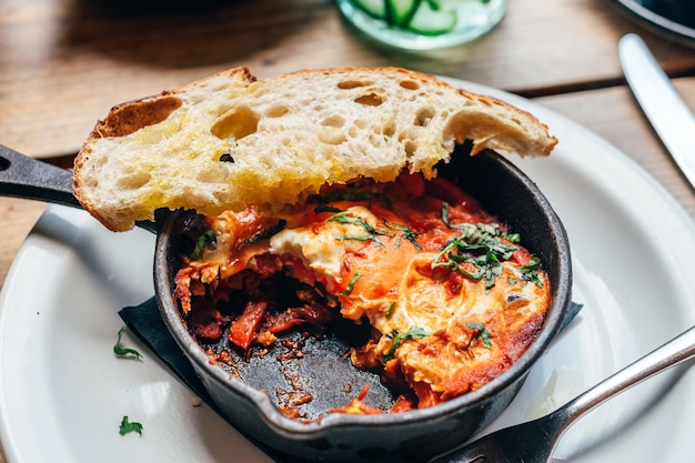 Shakshuka in padella di ferro servito con pane