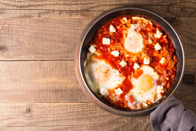 Foto shakshuka fatto di uova cotte in salsa al peperoncino di pomodoro