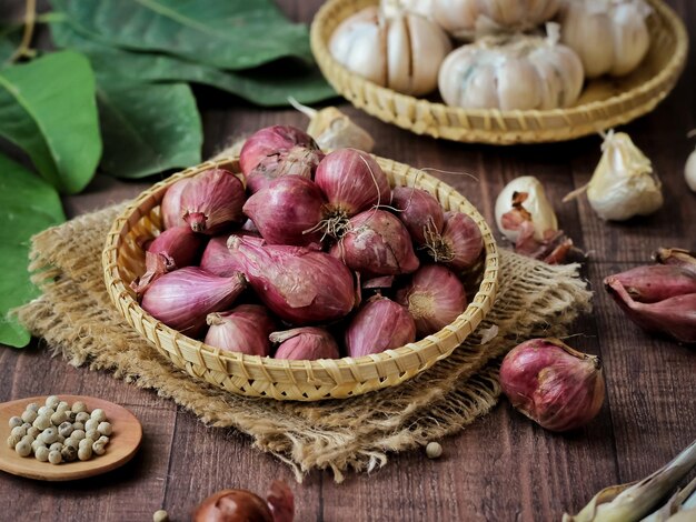 Shallot in a rustic bamboo plate. Brown wood textured background