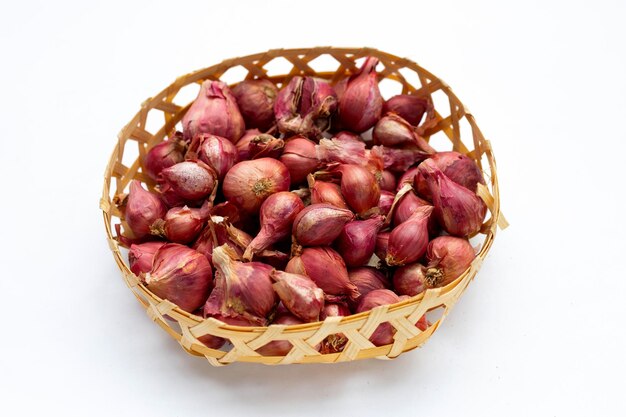 Shallots onion isolated in bamboo basket on white background