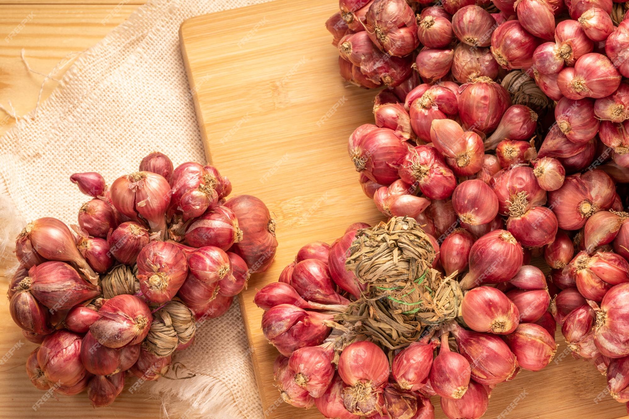 Premium Photo  Shallots or red onion purple shallots on wooden background  fresh shallot for medicinal products or herbs and spices thai food made  from this raw shallot