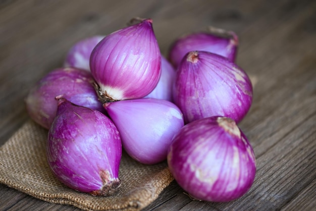 Scalogno o cipolla rossa scalogno viola su fondo di legno scalogno fresco per prodotti medicinali o erbe e spezie cibo tailandese a base di questo scalogno crudo